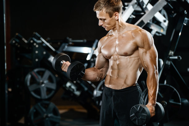 英俊的模特年轻男子在健身房锻炼图片下载