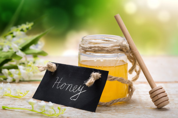 蜂蜜在罐子里，放在木桌上图片下载