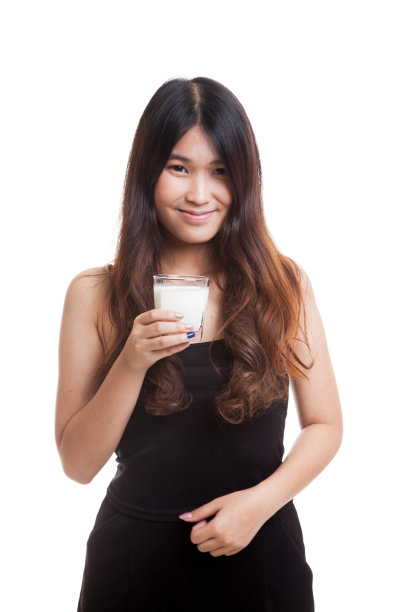 一个健康的亚洲女人喝一杯牛奶。图片下载