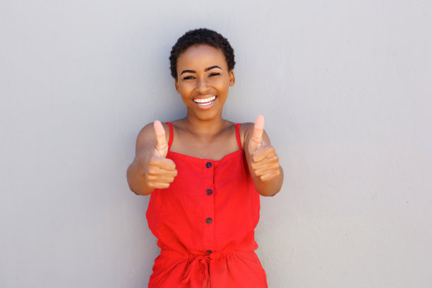 美丽的年轻黑人妇女微笑拇指向上的手势素材图片