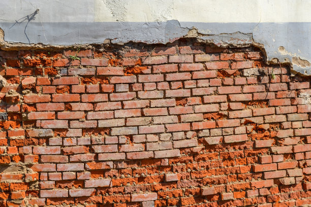 空旧砖墙纹理。建筑物破旧的正面，灰泥损坏了。图片下载