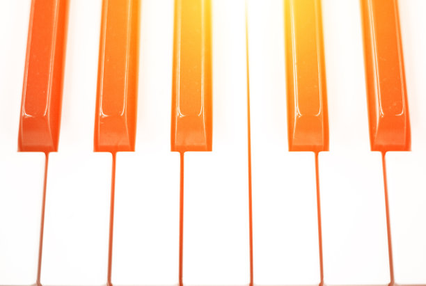 钢琴琴键在黄色灯光调的照片。黑白键盘乐器图片下载