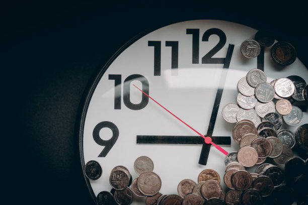 硬币，钱在钟上，聚焦在钟的中心，静物。节约金钱、财务报表、时间就是金钱和财富的概念。图片下载