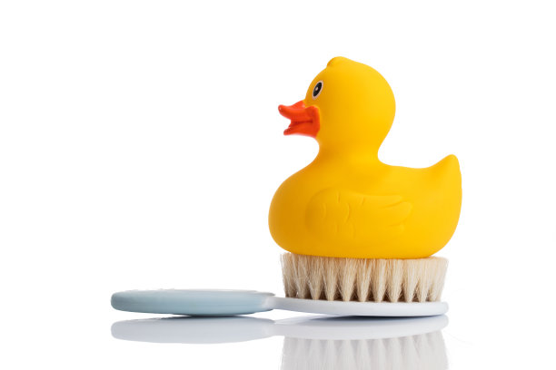 白色背景上的黄色橡皮鸭和毛刷图片下载