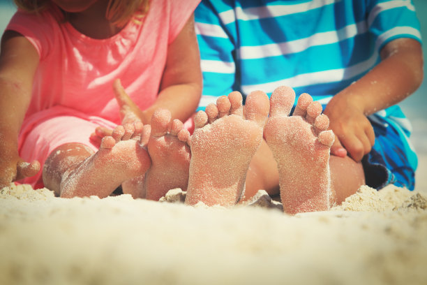 孩子脚踩沙滩，度假概念图片下载