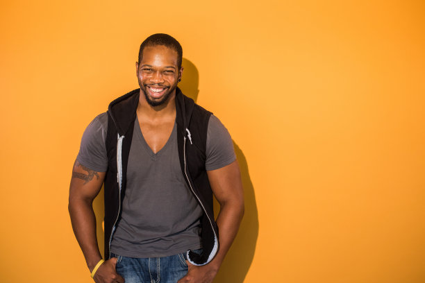 橙色背景下自信的黑人素材图片