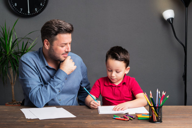父亲和儿子一起做作业。图片下载