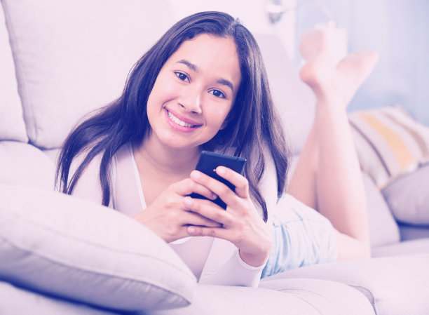 年轻高兴的女人躺着移动图片下载