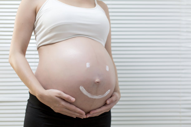 孕妇在腹部涂抹护肤霜图片下载