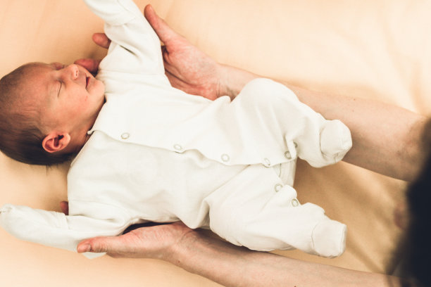 上图是一个熟睡的新生儿和她的母亲在床上的照片图片下载