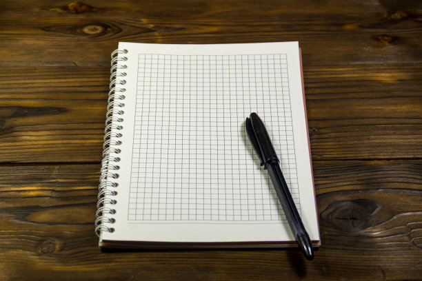 木桌上的空白笔记本和圆珠笔图片下载