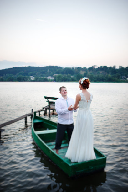 一对相爱的年轻夫妇坐在一条小船上玩耍图片下载