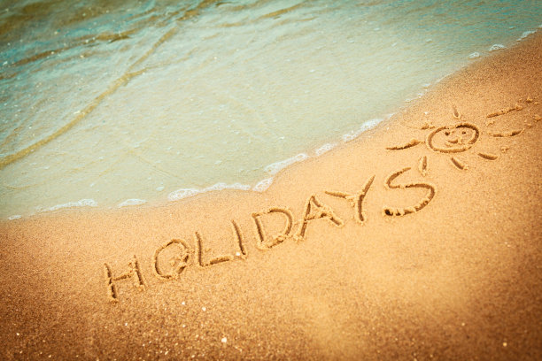 假期这个词写在沙滩上的沙子上图片下载