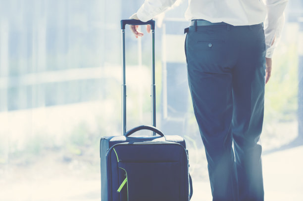 一个拿着箱子等在机场的商人图片下载