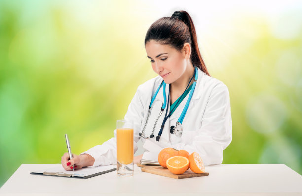 营养学家用新鲜的橙子和果汁写病历和处方图片下载
