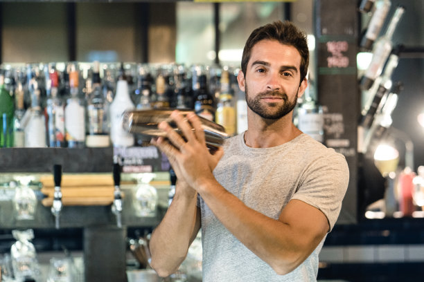酒吧调酒师使用鸡尾酒调酒器的肖像素材图片