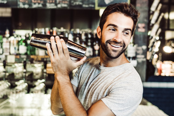 微笑的调酒师在调酒机在酒吧素材图片