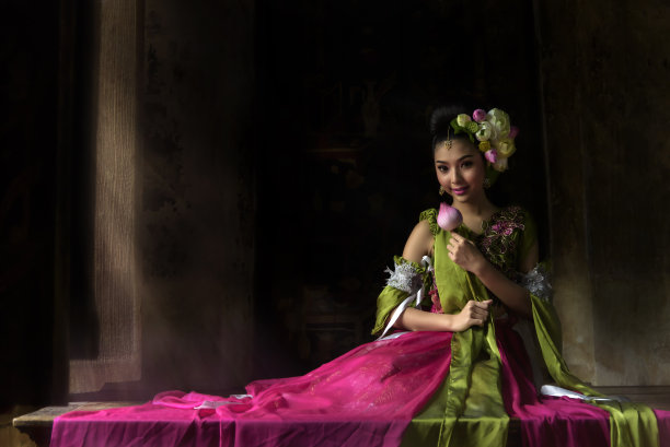 一个亚洲童话里的天使装饰着莲花坐在一张漂亮的木桌上。图片下载