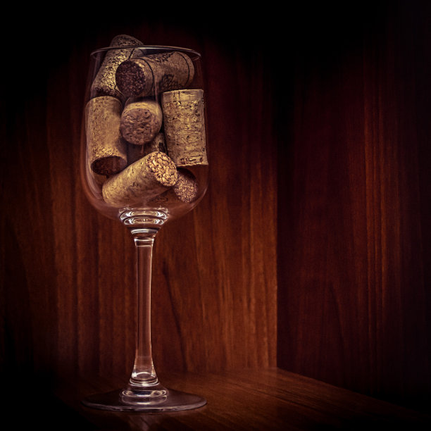 餐饮，派对概念:葡萄酒酒杯与软木塞在一个深色的木制背景的复古特写图像。有选择性的重点。图片下载