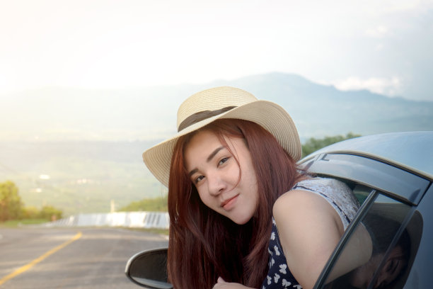 轻松愉快的旅行者，年轻美丽的亚洲女孩探出汽车和微笑的山路背景图片下载