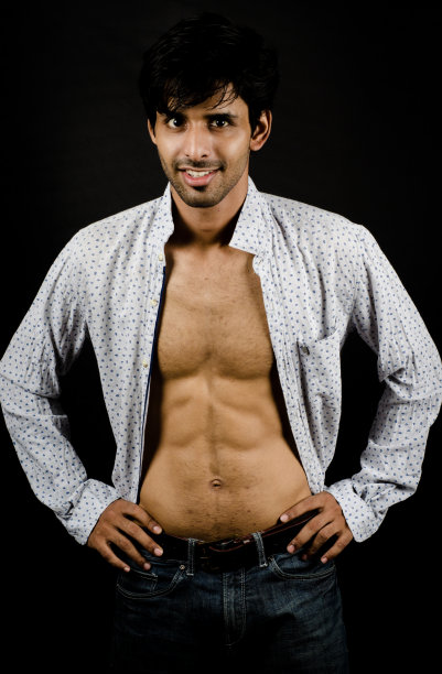 概念拍摄与聪明的亚洲人与腹肌穿着一件衬衫在愉快的心情在一个黑色的背景图片下载