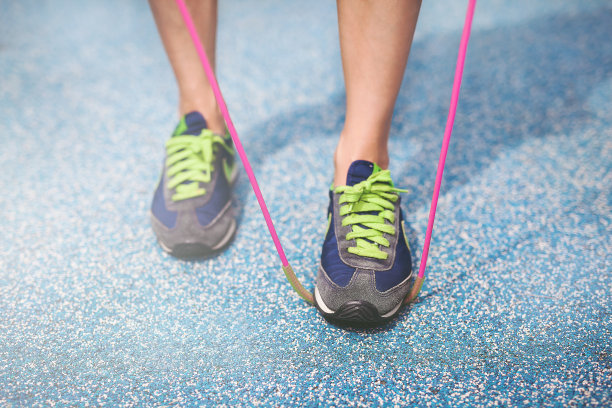 年轻女子在地上跳绳，近距离的脚图片下载