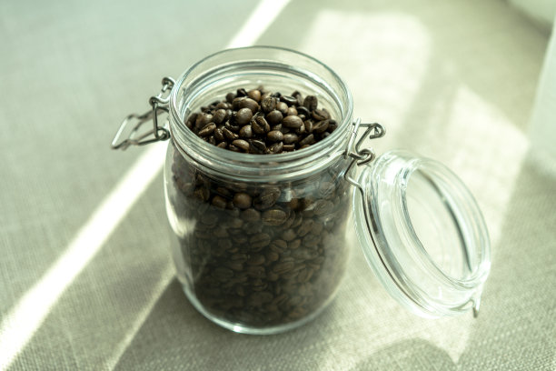 阳光下的玻璃瓶里的咖啡豆图片下载