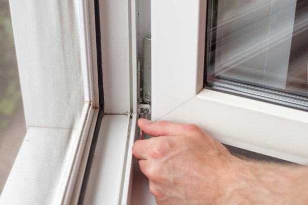 勤杂工用六边形修理塑料窗户。工人调整塑料窗的操作图片下载