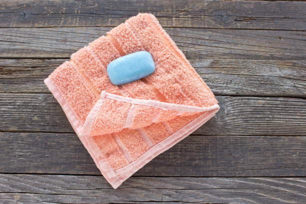 橙色的毛巾和肥皂在木制的背景图片下载