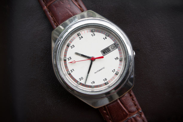 复古男士腕表上的黑色皮革背景。老人手表图片下载