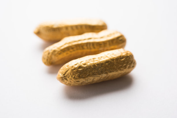 个性/脱颖而出/运气/财富/价值/排他性/更好的选择。金黄的花生或花生，在普通花生中突出，背景为黑色或白色图片下载