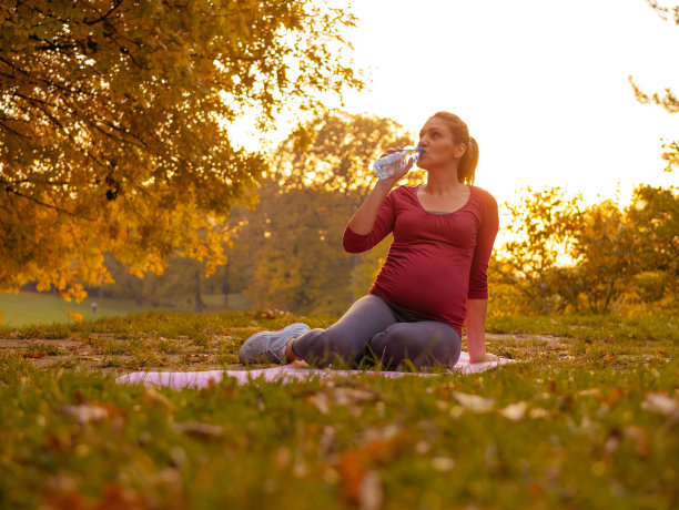 孕妇锻炼放松动作，享受阳光明媚的秋日图片下载
