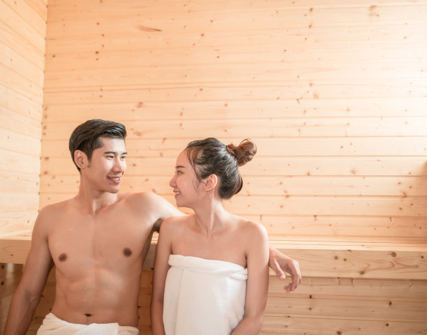 年轻夫妇在桑拿房内放松图片下载