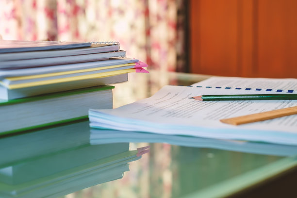 在起居室的桌子上有模糊的泰文教程文档表和考试书籍图片下载