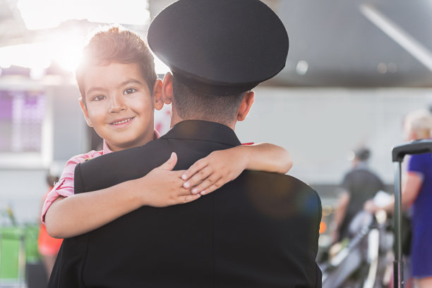 快乐微笑的小男孩拥抱父亲的飞行员图片下载