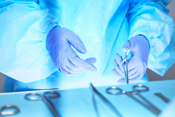 外科医生的双手在手术室工作的特写，色调为蓝色图片下载