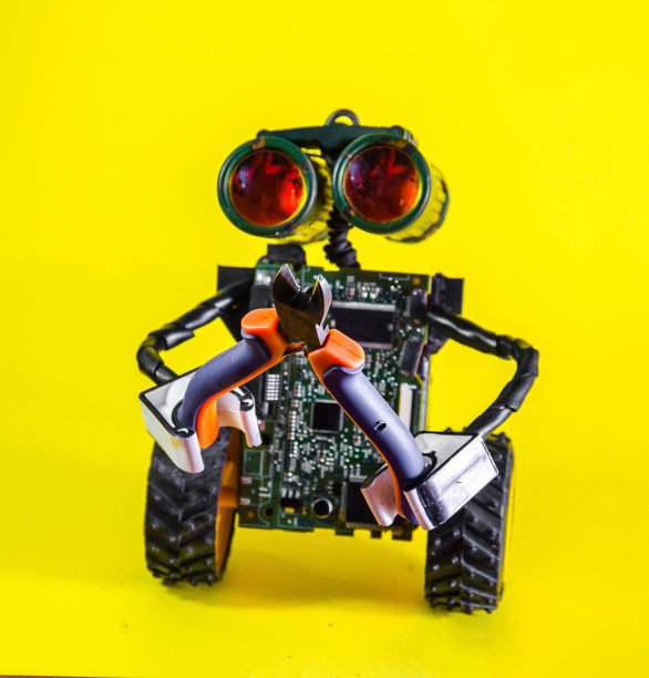 带有电线和轮子的未来机器人用钳子和刀具来修复破损图片下载