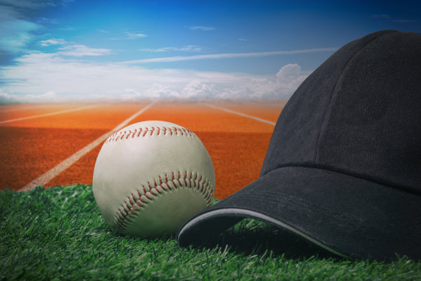 绿草地上戴着黑色的帽子和棒球图片下载