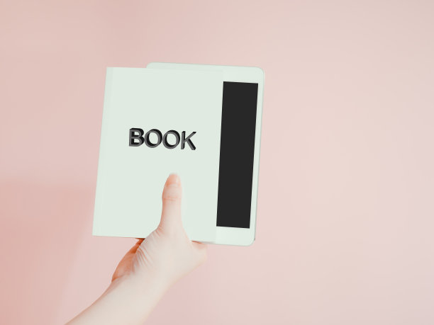 新技术的阅读(电子书)概念由亚洲女性右手拿着她的书和数字平板电脑与粉红色的柔和背景图片下载