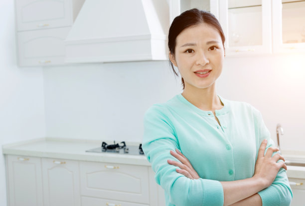 美丽的女人站在家庭厨房素材图片