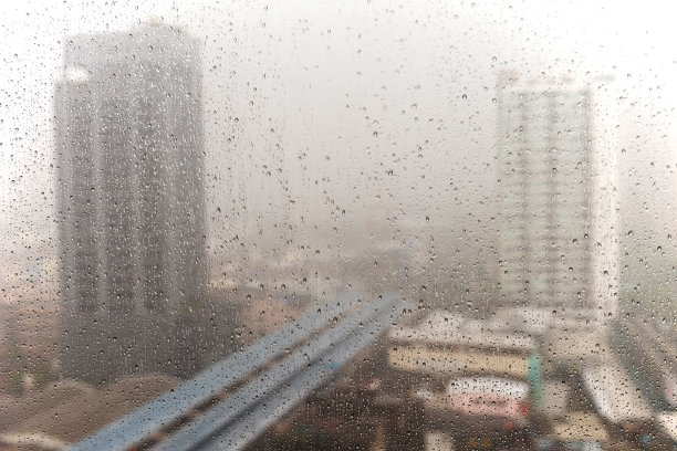 雨滴附着在曼谷城市的窗户上，泰国。热带风暴塔拉斯带来的暴雨导致曼谷许多地区洪水泛滥图片下载