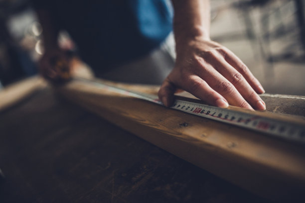 在一块木头上标注尺寸的木匠的特写。图片下载