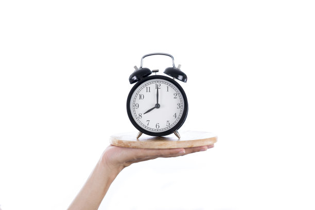 女人手拿托盘和闹钟在白色的背景，用餐时间和健康的概念图片下载