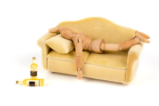 木制人体模型放松并睡在沙发上——沙发土豆图片下载