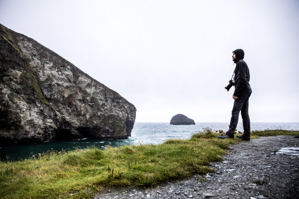 独自旅行者探索岩石海岸在康沃尔，英国图片下载