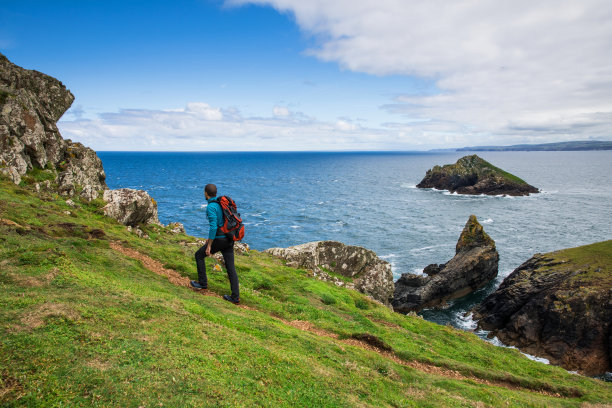 独自旅行者探索岩石海岸在康沃尔，英国图片下载