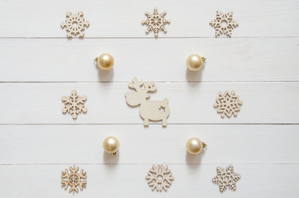 圣诞节假日简约背景。白色木桌上的圣诞装饰品、驯鹿和金色球图片下载