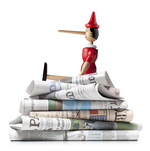 假新闻。一堆国际报纸上的匹诺曹。素材图片