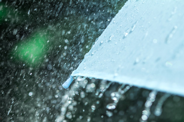 选择焦点特写伞的一部分，有雨滴下落，浅景深图片下载