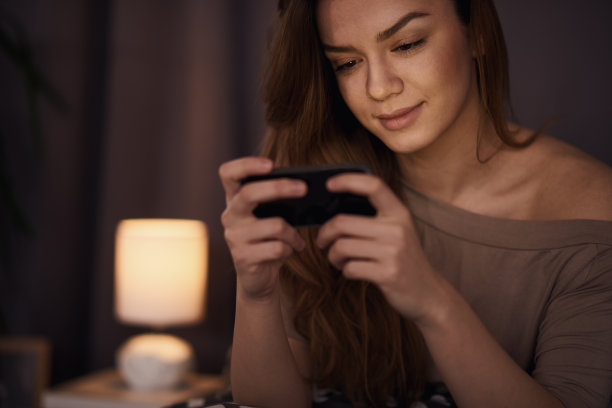 女孩在床上玩手机图片下载